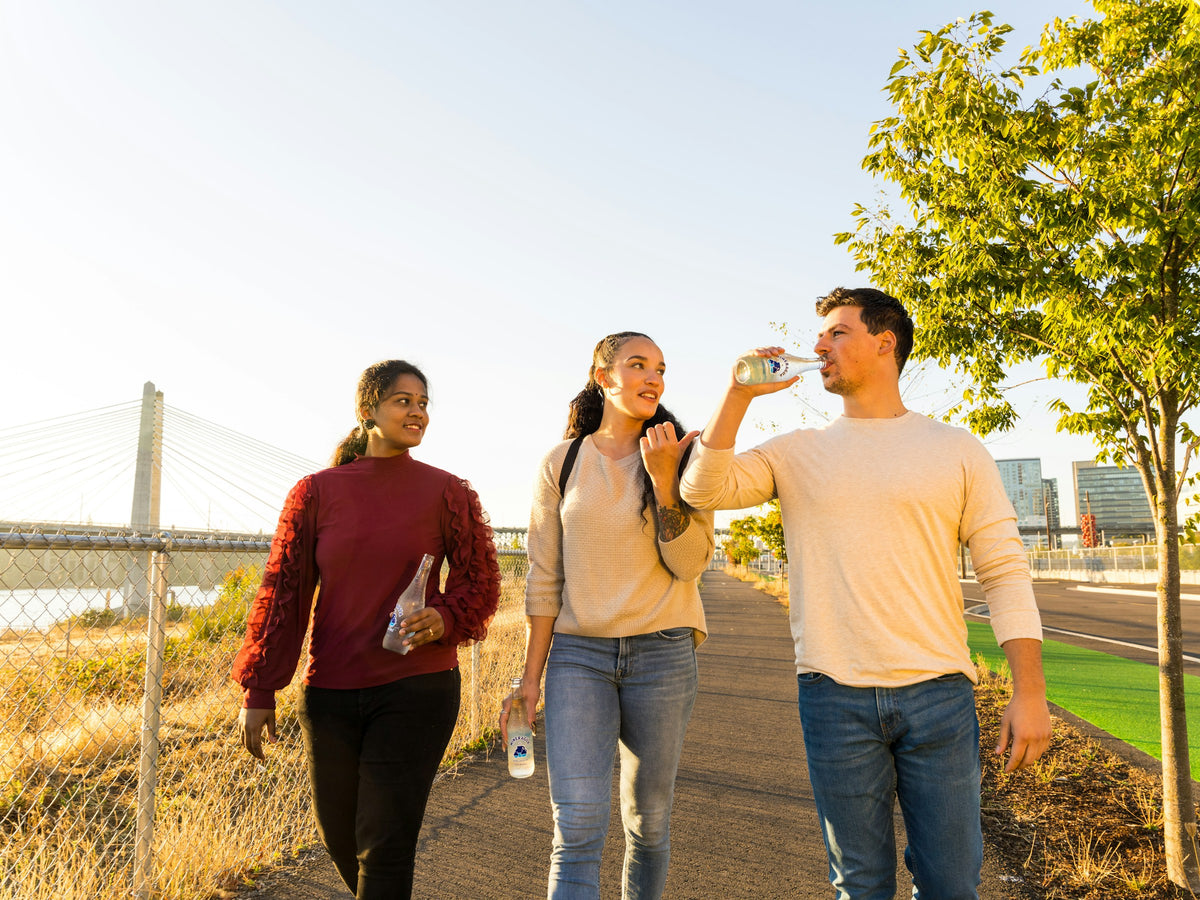 Three friends walking along the waterfront at golden hour